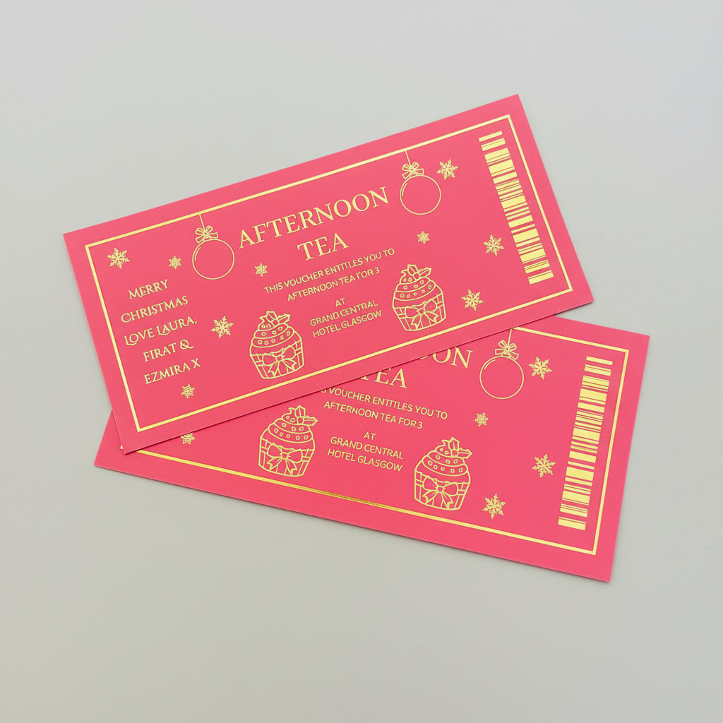 Pink voucher for afternoon tea with gold text and graphics held by a hand.